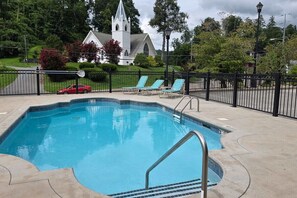 A swimming pool with a church in the background. - Creekside Condo with Pool, Walk Downtown (Gatlinburg)