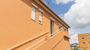 A building with a beige exterior, white window shutters, and a white railing on the exterior staircase. - Fully equipped apartment in Barroselas, Viana do Castelo (Barroselas)