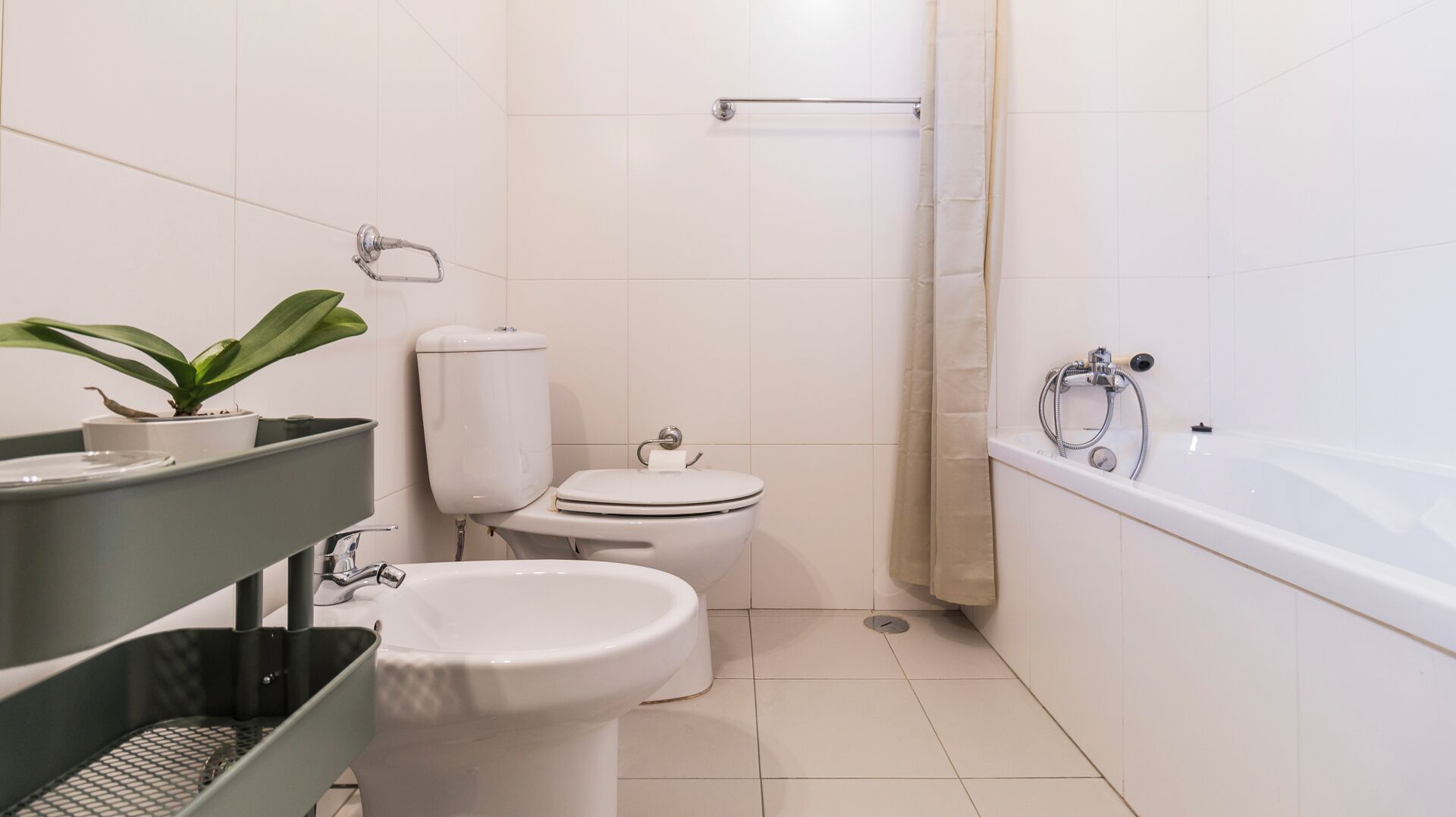 A modern bathroom with a toilet, bidet, and bathtub.