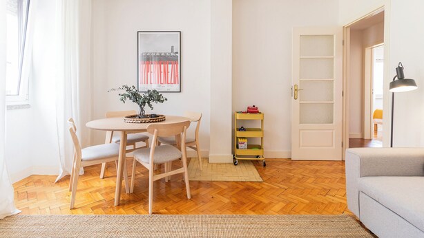 A living room with a round wooden table, two chairs, a small plant, a bookshelf, and a sofa. - Fully equipped apartment in Barroselas, Viana do Castelo (Barroselas)