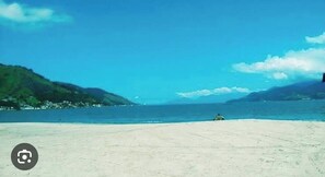 Uma praia com céu claro e mar calmo.