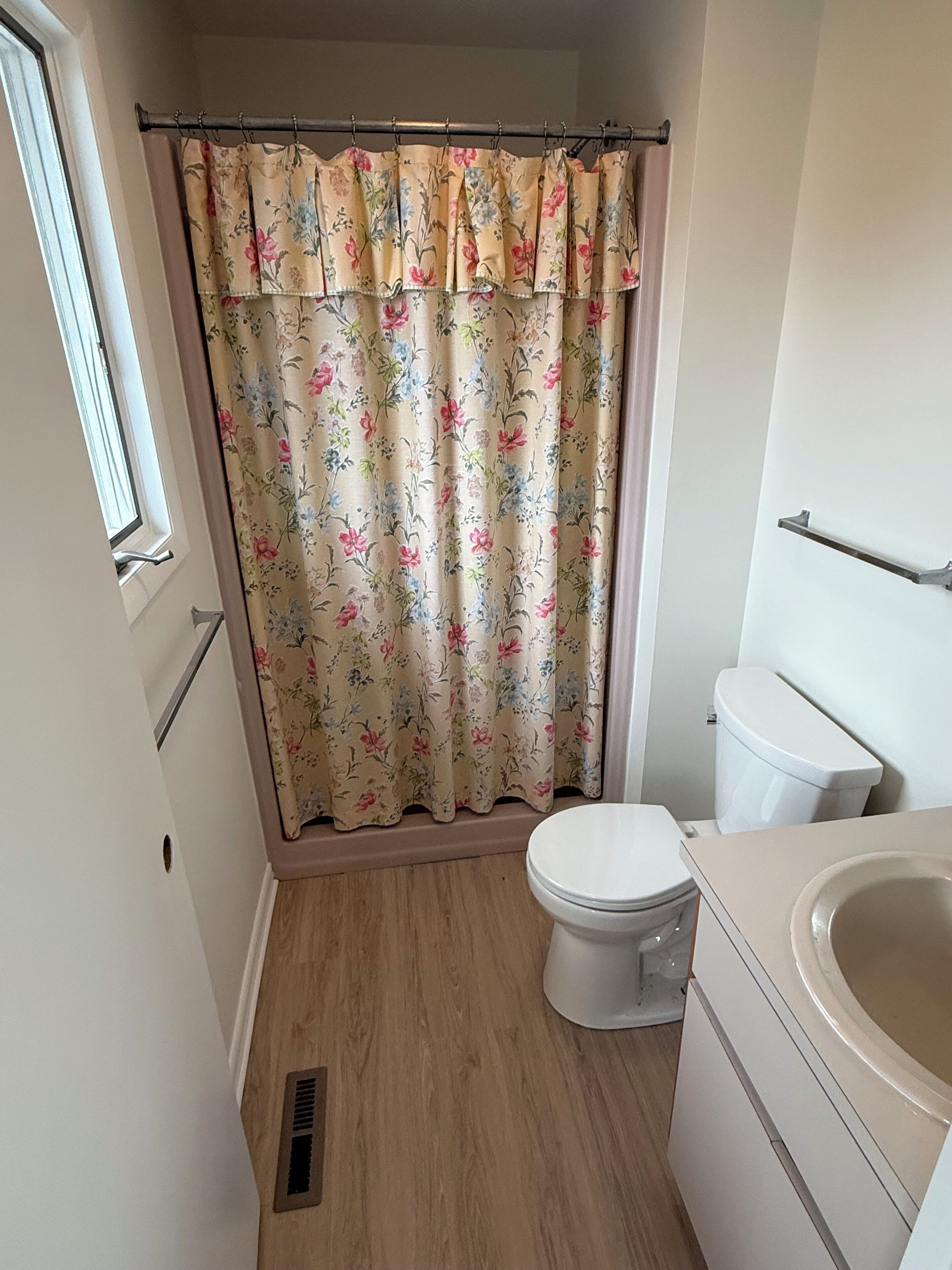 Een kleine badkamer met toilet, wastafel en douchegordijn.