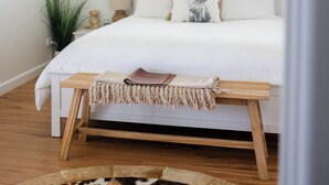A bedroom with a bed, a bedside table, a lamp, a window, and a patterned rug. - Drovers Run B&B and Events Venue (Marrar)