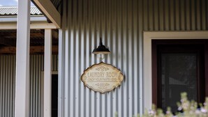 A laundry room sign on a corrugated metal wall with a hanging lantern above it. - Drovers Run B&B and Events Venue (Marrar)