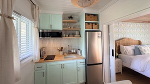A compact kitchen with a microwave, toaster, and refrigerator.