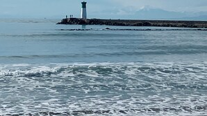 A lighthouse on a rocky outcrop in the sea with waves crashing onto the shore. - La Casa Polo & Lea: Ground Floor, Oceanfront – Direct Beach Access (Agde)