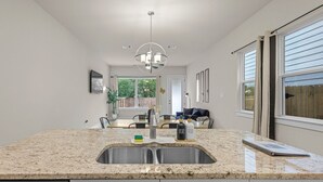 A kitchen with granite countertops, a stainless steel sink, and a dishwasher. - Modern 3BR Near RiverWalk•Sleeps 8•Free Parking (San Antonio)
