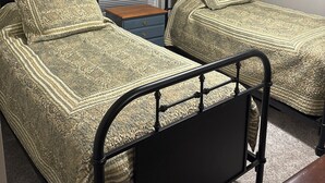 A bedroom with two twin beds, a window with blinds, a ceiling fan, and two mounted deer skulls on the wall. - Simple Comfort 2-bedroom home 4.5 miles from the Augusta National Golf Course! (Augusta)