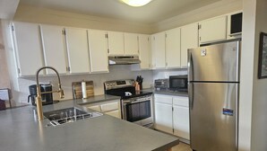 A modern kitchen with white cabinets, stainless steel appliances, and a grey countertop. - Recently remodeled first floor, beautiful views of the lifts/mountains! (Mammoth Lakes)