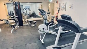 Ein Fitnessstudio mit Laufbändern, Crosstrainern und Gewichten.