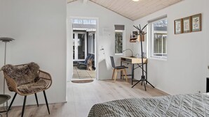 Una habitación con cama, silla, escritorio y ventana.