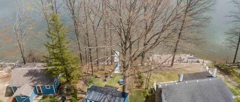 A lakeside property with multiple cabins, a dock, and a boat.