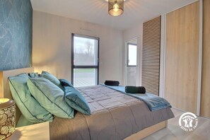 A bedroom with a bed, pillows, a bedside table, and a window. - Chez Anne - 4 people (BADEN)