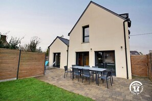 A modern two-story house with a patio area featuring a dining table and chairs. - Chez Anne - 4 people (BADEN)