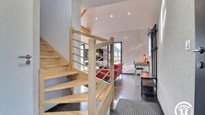 Un interior moderno con una escalera de madera que conduce a una sala de estar.