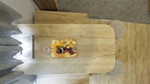 Une table en bois sur laquelle sont disposés divers fromages, des crackers et des raisins.