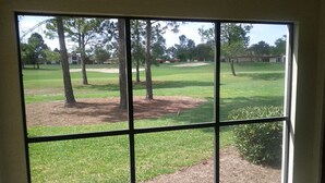 A room with a large window overlooking a golf course.