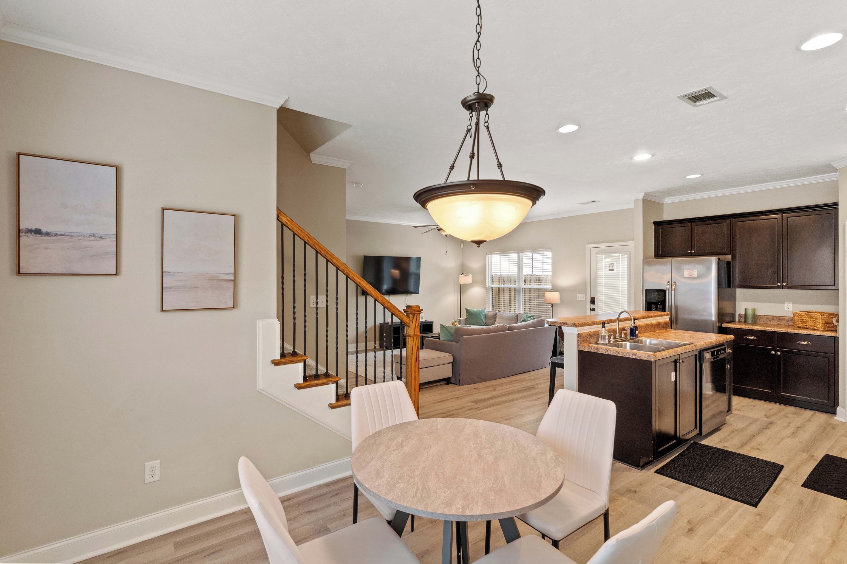 A modern kitchen with dark cabinets, a stainless steel refrigerator, and a granite countertop.