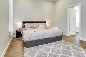 Une chambre à coucher avec un lit, des tables de chevet et une porte.