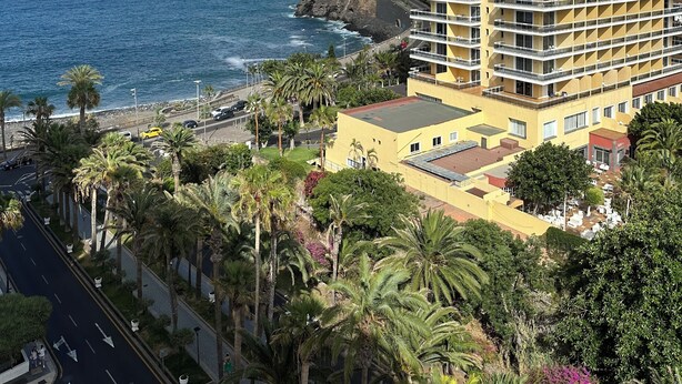 A high-rise hotel with multiple balconies, located near a coastal area with a view of the sea and a rocky coastline. - Palmeraie Studio - Sea view and pool (Puerto de la Cruz)