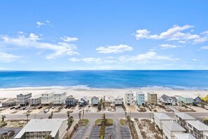 A coastal hotel with a beachfront view, featuring a row of buildings with parking in front. - 3 BR 3 BA spacious condo~Gulf Shores~25% DISC FOR WEEKLY RENTAL-Gulf/lagoon view (Gulf Shores)
