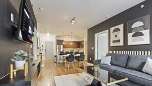 A modern living room with a grey sofa, a coffee table, and a TV mounted on the wall. - Great for Children with bunk Beds (Frisco)