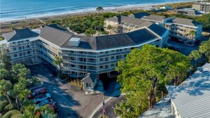 A multi-story hotel with a curved roofline, located near a beach with a clear view of the ocean. - Breakers 324 Oceanfront Hilton Head Condo Direct Beach Access (Hilton Head Island)