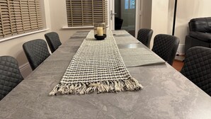 Ett konferensrum med ett långt bord, svarta stolar, en mönstrad matta och en skylt som visar utgången i händelse av brand.