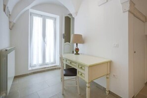 A room with a white desk, a chair, a lamp, and a window with curtains. - Giona's guest house (Martina Franca)