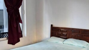 A bedroom with a bed, a window with curtains, and a tiled floor. - Hotel Villas Punta Peñasco (Acapulco)