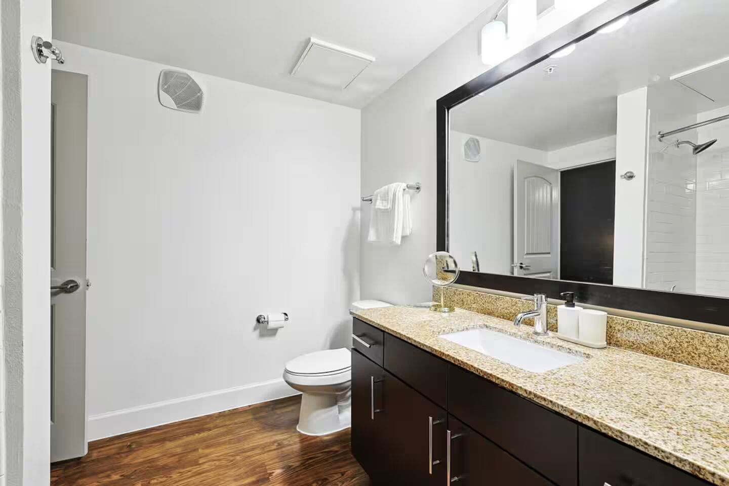 A modern bathroom with a toilet, sink, and mirror.