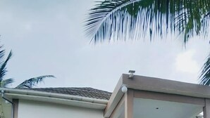 Una casa de dos pisos con un balcón, una escalera y un césped bien cuidado.