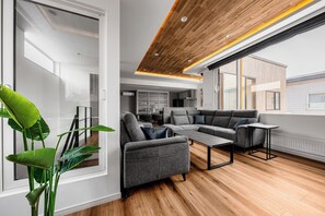 A modern living room with a sectional sofa, a coffee table, and a potted plant. - TDR Toti Design Room (Furano)