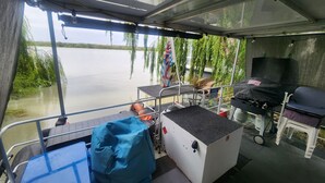 Ein Bootinnenraum mit Tisch, Stühlen und Grillbereich.