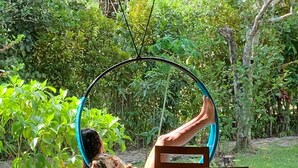 Una persona sentada en una silla dentro de una estructura circular tipo hamaca.