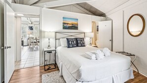 Camera moderna con un letto grande, un comodino, una scrivania e vista sull'area pranzo.