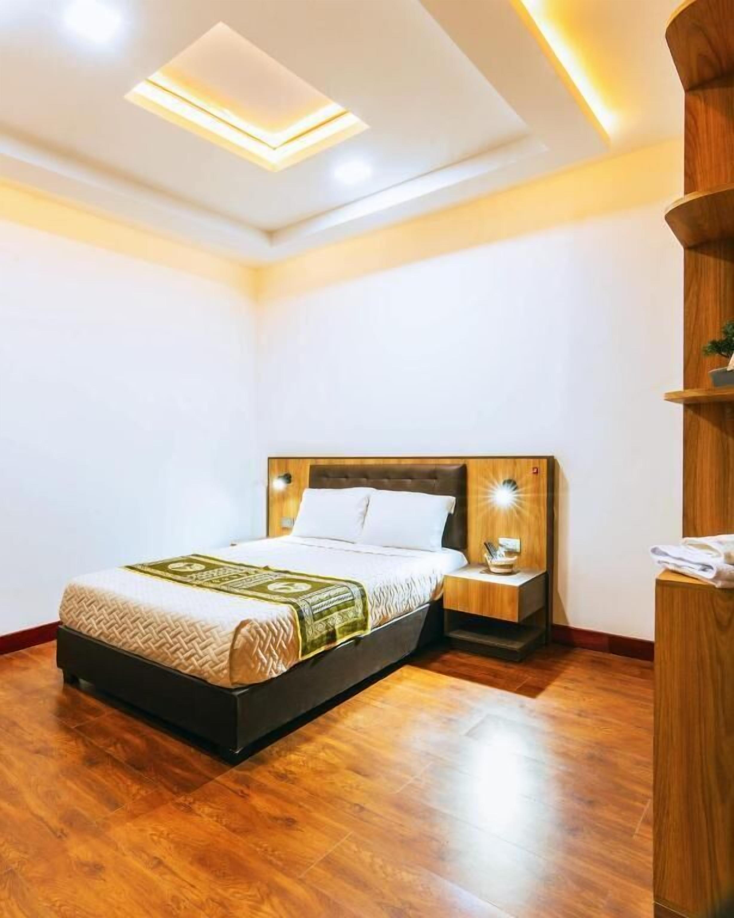 Ein modernes Schlafzimmer mit einem hölzernen Bett, einem Nachttisch und einer eingebauten Ablage.