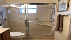 Ein Badezimmer mit einer Duschkabine, einer Toilette und einem Waschbecken.