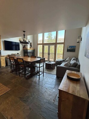 A spacious living area with a dining table, sofa, and a fireplace.