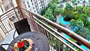 A balcony with a table, a view of a resort area, and a pool. - Relaxing 1-bedroom resort with AC in marvelous Las Vegas (Las Vegas)