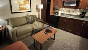 A compact living space with a sofa, a coffee table, a kitchenette with a microwave, and a framed picture on the wall. - Relaxing 1-bedroom resort with AC in marvelous Las Vegas (Las Vegas)
