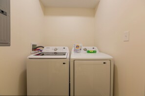 Une buanderie équipée de deux machines à laver à chargement frontal et d’un sèche-linge.