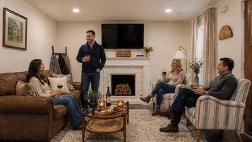 A living room with a fireplace, a television, and a coffee table with snacks.