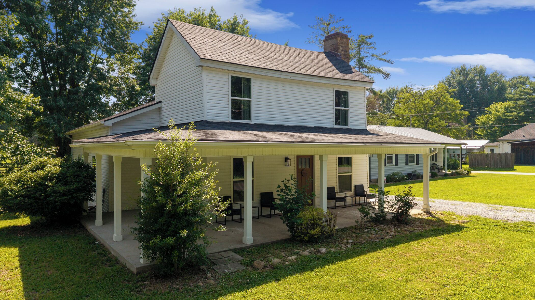 A two-story house with a covered porch and a well-maintained lawn.