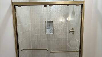 Een douche, handdoeken, zeep, shampoo