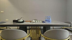 A conference room with a table, chairs, a water dispenser, and a tissue box.