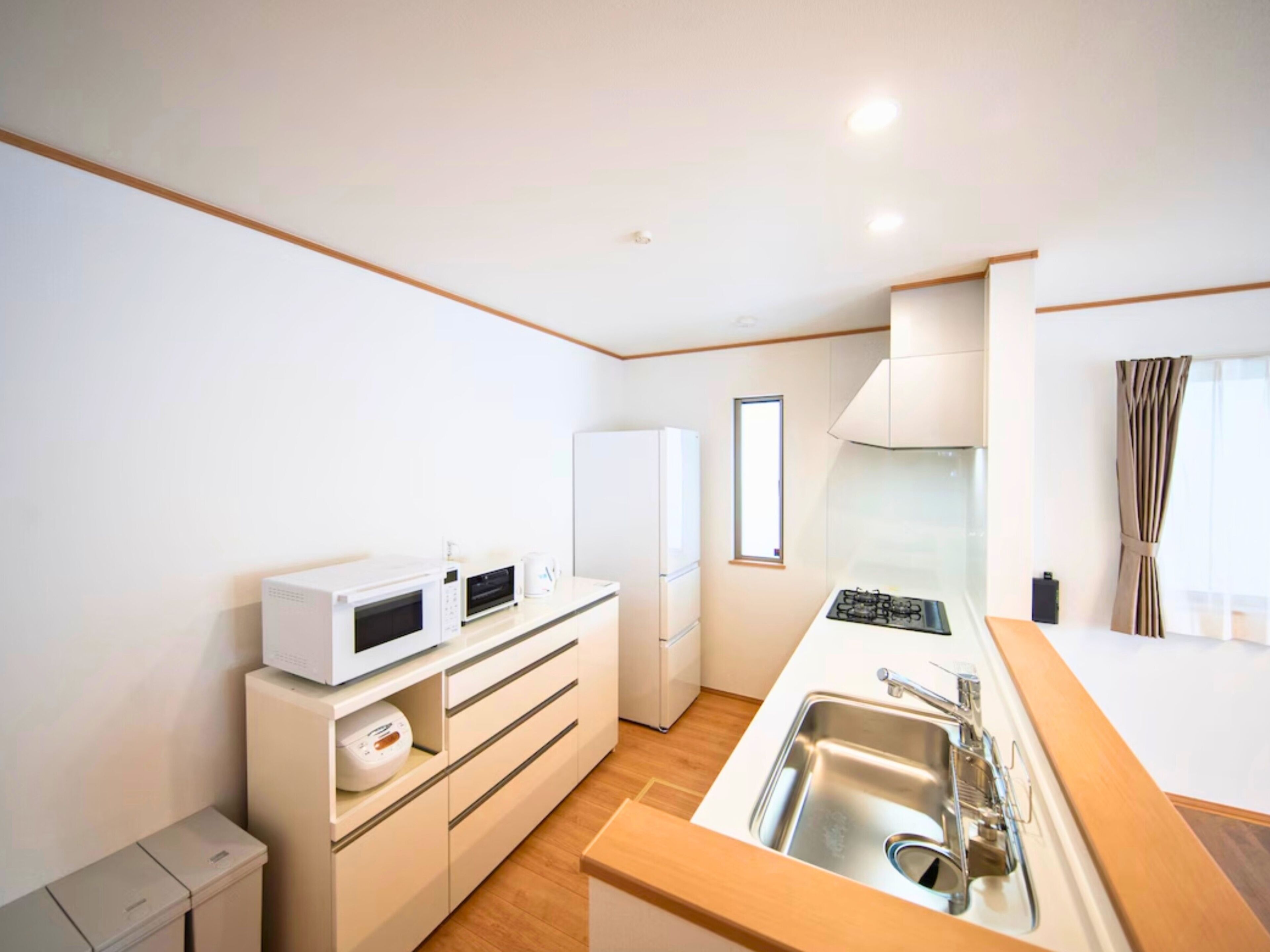 A compact kitchen with a microwave, refrigerator, and stove.