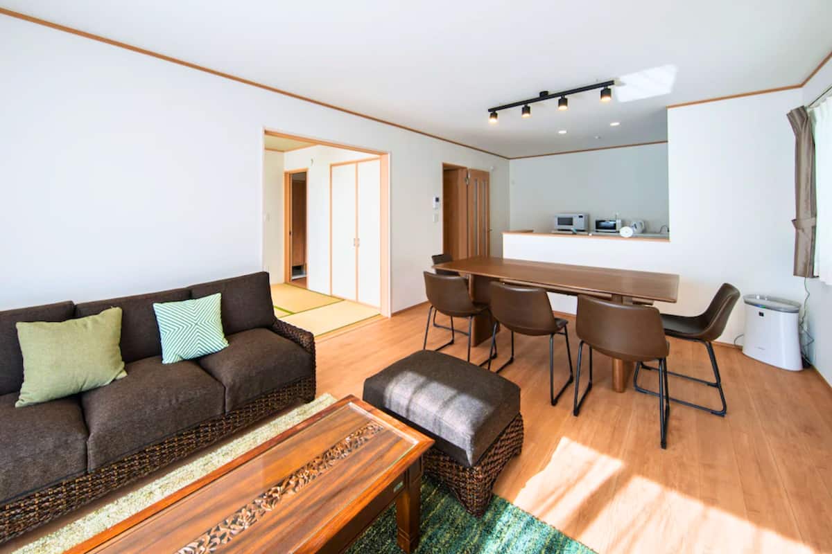 Un salon moderne avec un canapé, une table basse et un coin repas.