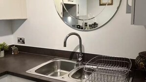 A modern kitchen with a stainless steel sink, a round mirror, and a dish rack. - Best location! Shoreditch 5 min walk Old St Tube (London)