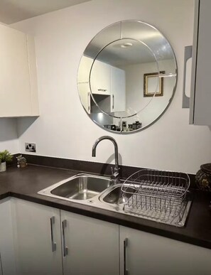 A modern kitchen with a stainless steel sink, a round mirror, and a dish rack. - Best location! Shoreditch 5 min walk Old St Tube (London)